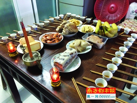7日下午,上海郊区一户人家祭祖,八仙桌上摆年菜,酒盅,筷子,同时燃