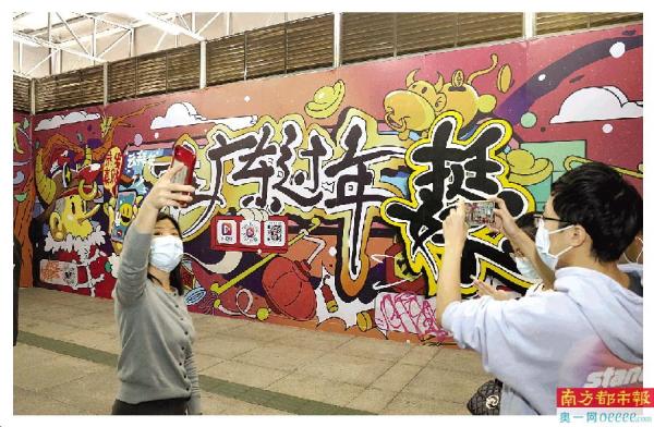 2月3日,广州杨箕地铁站,市民在主题涂鸦艺术墙合影留念.